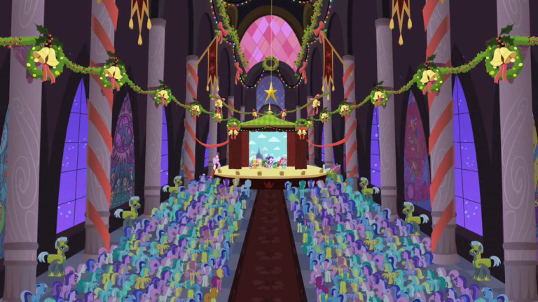 A back-facing shot of hundreds of ponies gathered in front of a stage in a large hall decorated with bells and wreaths. The Mane Six are barely visible on the stage.