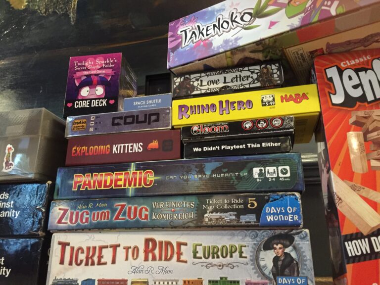A large pile of tabletop games, including Takenoko, Twilight Sparkle's Secret Shipfic Folder, Love Letter, Coup, Rhino Hero, Gloom, Exploding Kittens, We Didn't Playtest This Either, Pandemic, Ticket to Ride, Jenga, and Cards Against Humanity.